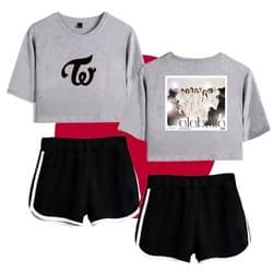 Kpop merch set featuring a grey cropped top with a black logo, a graphic t-shirt with group photo, and black shorts with white trim for casual concert wear.