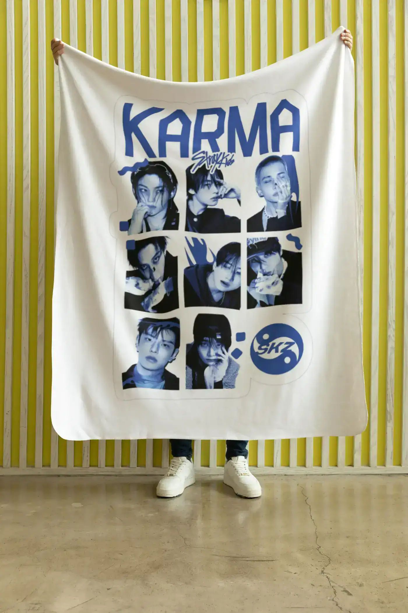 Kpop merchandise featuring members of SKZ, including a large printed blanket with portraits of the group members.