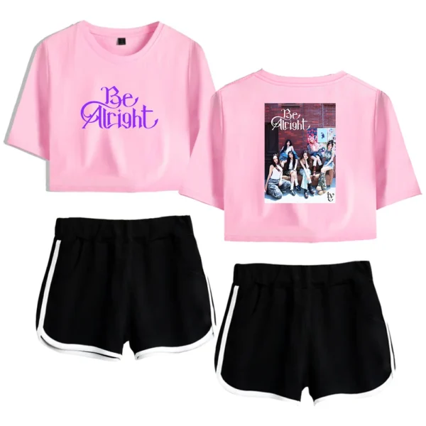 Casual pink crop top with "Be Alright" text and a group photo on the back, paired with black and white athletic shorts, perfect for K-pop fan merchandise.