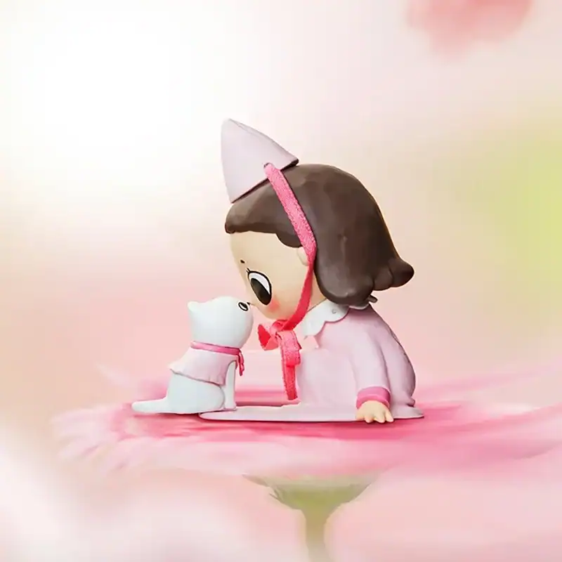 Cute girl elf figurine with a white cat wearing a pink dress and hat, sitting on a soft pink flower background, perfect for kpop merch collections.