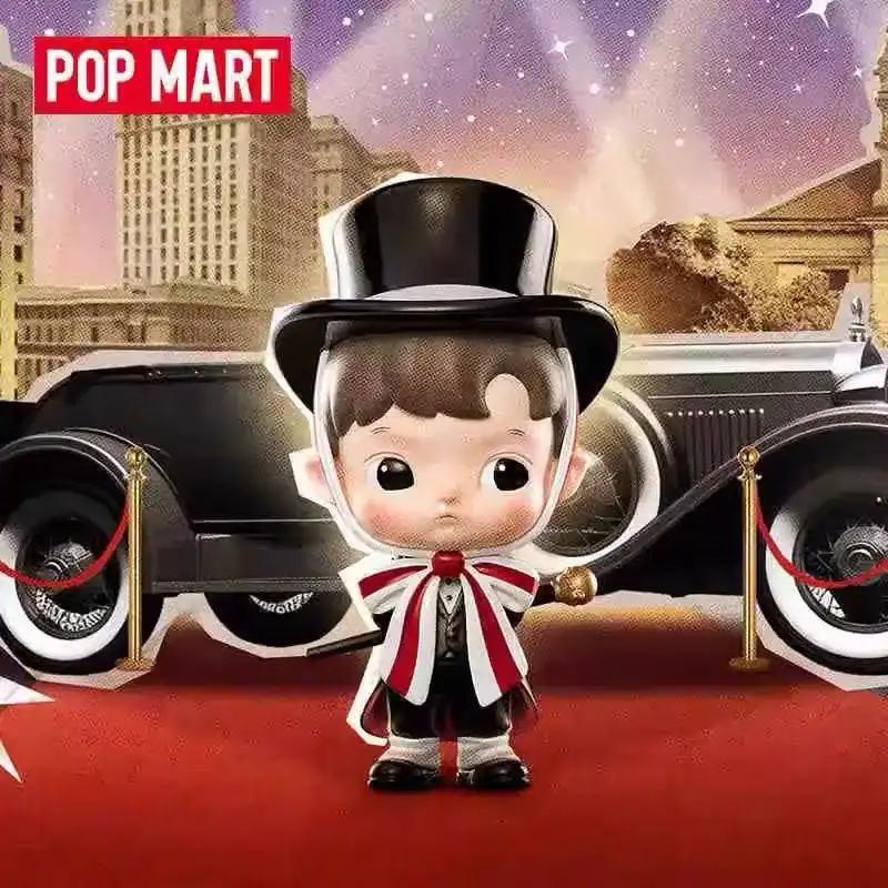 Cute K-pop merch figure with a top hat and bowtie in front of a vintage car, set on a red carpet with a cityscape background.