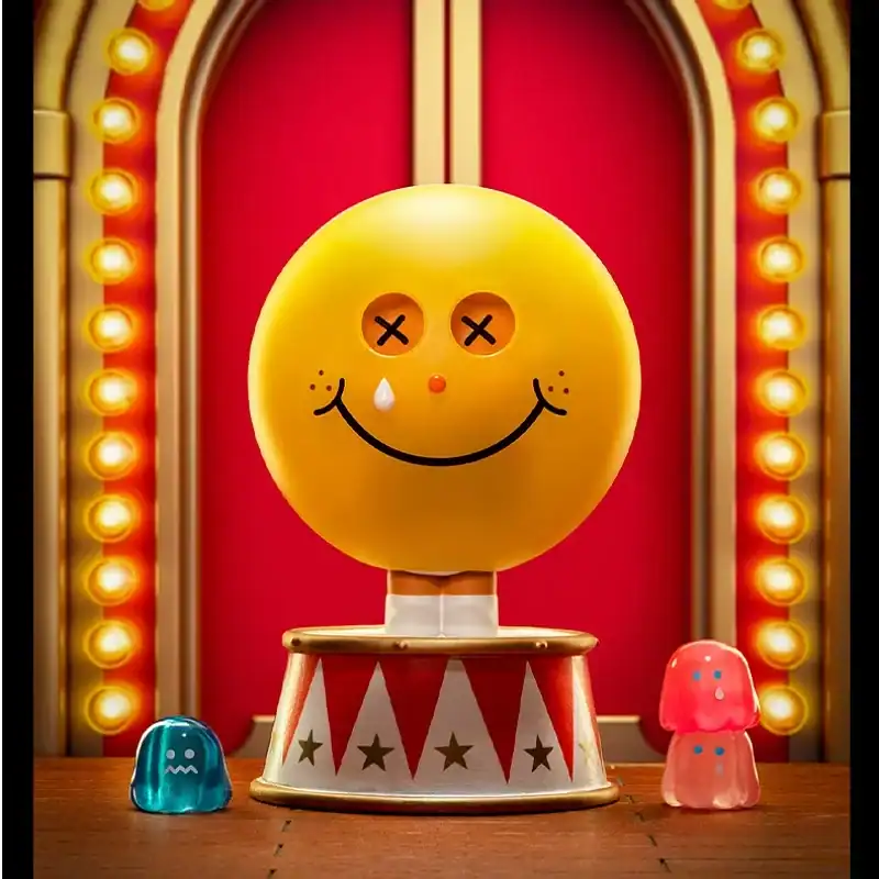 Yellow smiley face plush toy with button eyes and water drop, colorful character collectibles on wooden table, playful plush toys and figures, vibrant carnival-like background with lights.