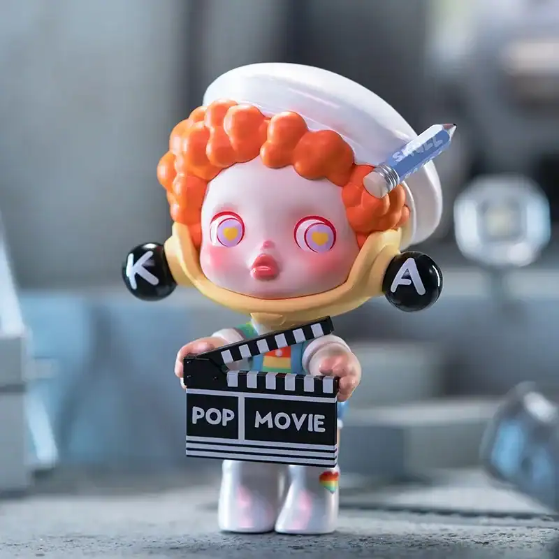 Colorful K-pop themed character figure holding a film clapperboard, with a playful expression and vibrant details.